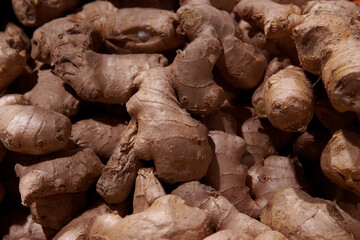 A pile of ginger root in the grocery store. Healthy natural product at the market place. Traditional medicine ingredient.