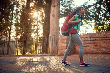 young woman enjoying in active sightseeing in italy, hiking with backpack