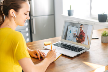 Webinars, online learning, online classes. A female student using laptop for watching lectures...