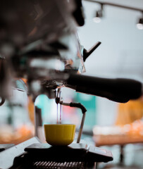 Espresso pouring from coffee machine into coffee cup.