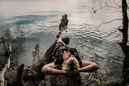 Europe, Germany, Berlin, Mueggelheim, Grosse Krampe, woman relaxing on a tree in the lake.