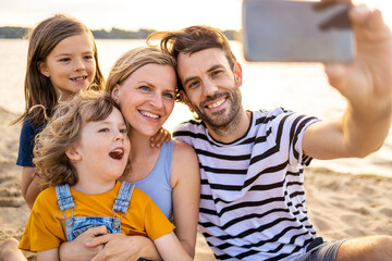 Family taking self portrait on beach
