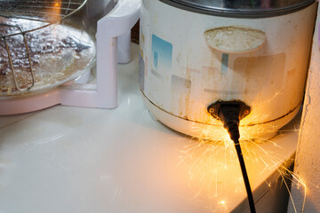 Electric short, plug, rice cooker Therefore causing sparks Dangerous concepts from the use of old electrical appliances And without quality Therefore is dangerous to life and property