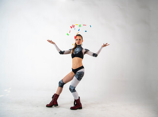 beautiful brunette girl in a robot suit takes gymnastic poses on a white background