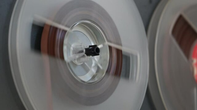 Vintage reel to reel tape recorder playing music. Spinning reels on old tape recorder. Close up. Play. Stop.