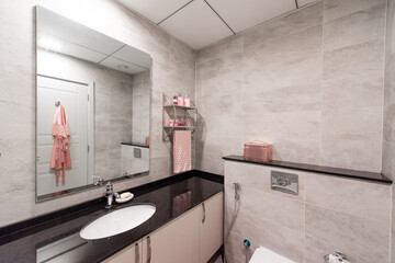 modern bathroom sink and morroe with pink accesories and decorative elemnts.