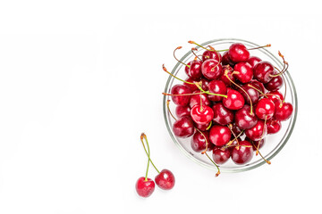 Obraz na płótnie Canvas Bowl of fresh cherries and two berries near bowl on white background. Copy space for text