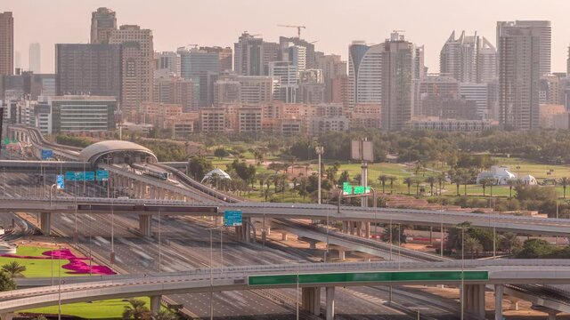 Dubai Golf Course with a cityscape of Gereens and tecom districts at the background aerial timelapse early morning during sunrise. Traffic on sheikh zayed road with junction