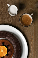 A double doughnut, coffee and milk on a wooden table.