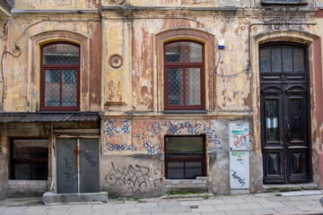 Fototapeta na wymiar building facade, with windows, doors, graffiti