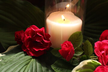 candle surrounded by roses