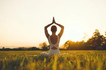 Fotobehang Yogaschool Jonge vrouw die yoga beoefent op de natuur.