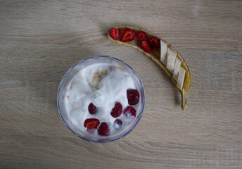 Top down view inside a blender as bananas, berries and milk are mixed into a smoothie.