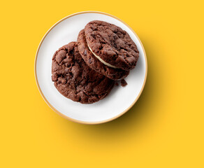 Cookies de chocolate y crema sobre fondo amarillo. Chocolate and cream cookies on yellow background.