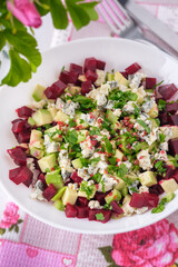 Beet salad with avocado, cilantro and blue cheese with mold on the table. Vegetarian dish