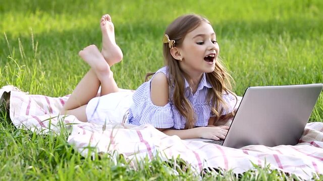 A caucasian newborn blogger telling information about herself, enjoying her free time, waving hands, lying on the blanket and speaking with friends through the Internet. Concept of technology.