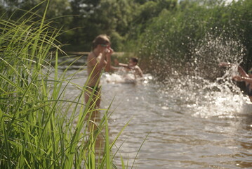 children bathe on the lake, partially blurred background