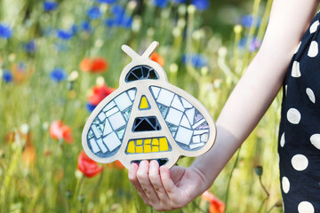 Bee with mosaic on a background of wildflowers.