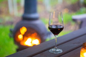 Glass of red wine by fire