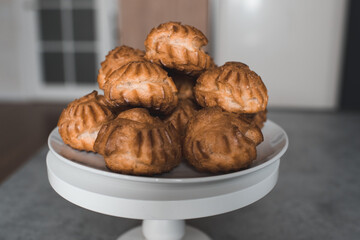 Homemade pastry with cream on plate in kitchen closeup. Cooking at home.