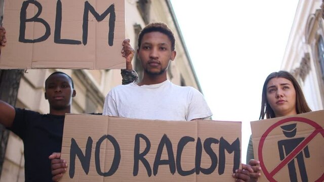 Mass protests in the USA. Multiracial group of people with posters BLM, police free zone, no racism. Rallies against racism and police brutality. Peaceful Black Lives Matter Protest City Street