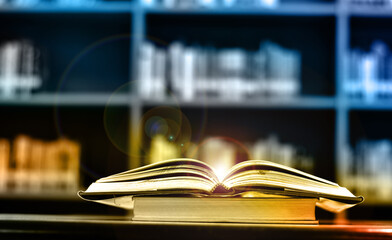 Open Book on wood table and blurred bookshelf in the library, education background, back to school concept.