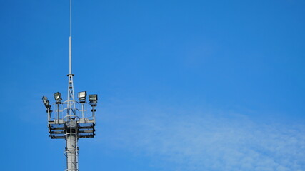 High lighting mast against the blue sky. View from below. Full height.
