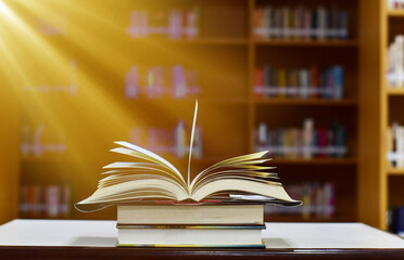 Open Book on wood table and blurred bookshelf in the library, education background, back to school concept.