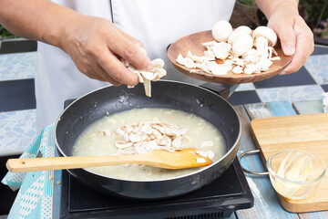 Chef pouring slice of mushroom cream soup