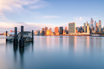 View on Midtown Manhattan and from East river with ferry stop during sunrise with long exposure