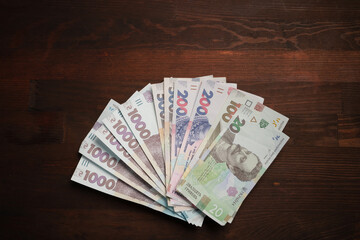 Money fan against of wooden table background. Pack of new Ukrainian paper hryvnias different face value. Deposit concept.