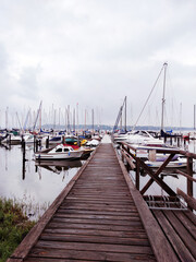 Sea bay with yachts with wooden bridge on foreground