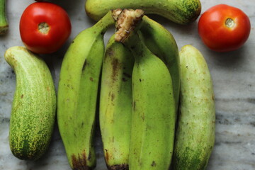Green cucumber display with selective focus and fresh various raw organic vegetables for healthy and diet background.