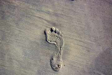 footprint on the wet sand of the sea