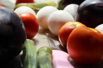Tomato and eggs display with selective focus and fresh various raw organic vegetables for healthy and diet background.