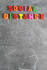 Information sign of social distance from letters on blackboard, top view
