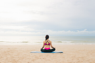 Fototapeta na wymiar Young woman practicing yoga outdoor on the beach in morning