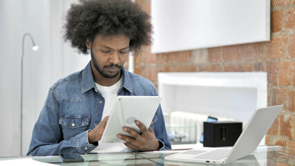 African Man Browsing Internet on Tablet