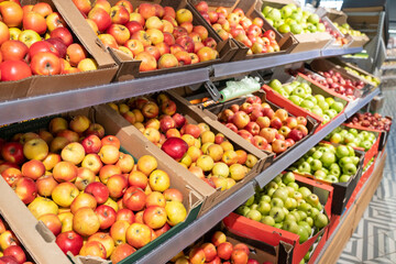 Store shelves filled with red and green apples. Box filled with green and red apples at a supermarket