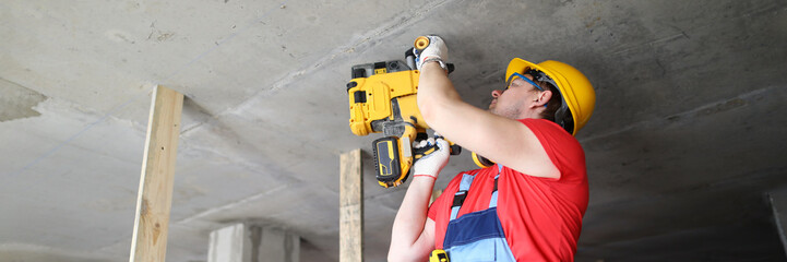 Builder works with special equipment on ceiling