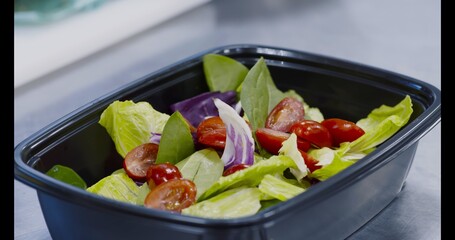 Chef preparing fresh salad for takeaway delivery order