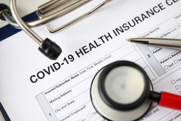 Silver pen lying at covid-19 insurance claim blank