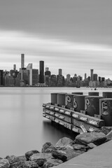 View on the Midtown Manhattan from east river pier with long exposure on a cloudy morning in black and white photo