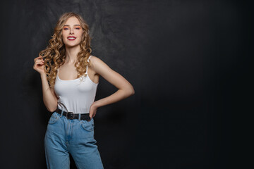 Naklejka premium Pretty blonde woman in blue denim on black banner background with copy space