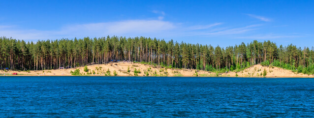 The picturesque lake in Toksovo village, beautiful panoramic view of the lake against the forest background, Leningrad region, Russia