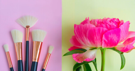 Obraz na płótnie Canvas premium makeup brushes and pink peony flower on a colored pink and yellow background, creative cosmetics flat lay