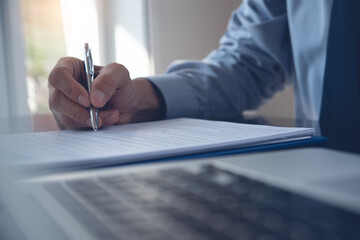 Close up of businessman hand signing business contract in office for business agreement concept