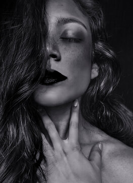 Intense beautiful woman  with freckles and hand on neck  portrait -  wavy hair - black and white