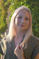 Portrait of happy blonde young woman in a park