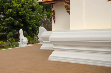 White concrete wall and base of Thai chuch on red floor © athapet